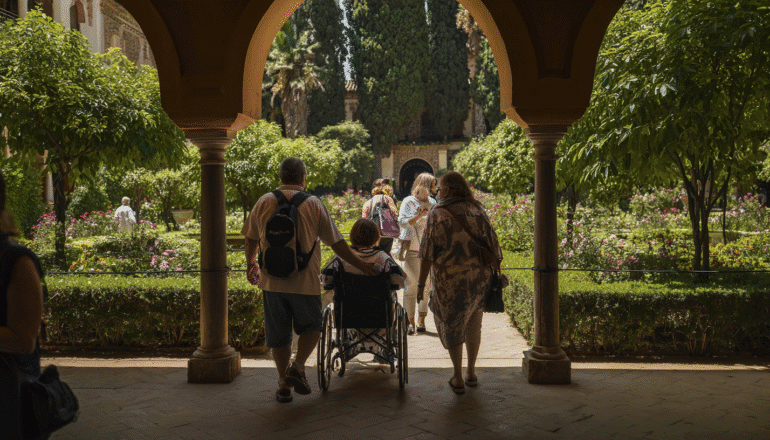 turistas disfrutando de un recorrido guiado accesible en los jardines del Real Alcázar.